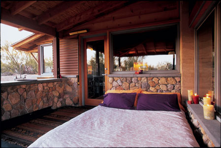 River rock and wood-plank flooring create a rustic feel in this unscreened sleeping porch in Tucson, Arizona. Located off the home’s master bedroom and bath, it’s used for sleeping about six months out of the year.